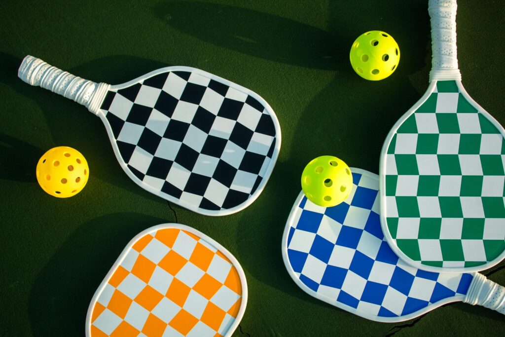 Image is about the balls and bats used in the pickle ball game.